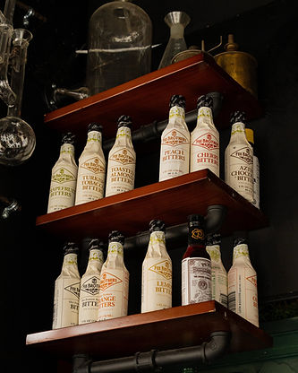 a shelf of free brother's bitters t inside Madame Rochéle's Apothecary, a high-end cocktail bar in Harrisburg, PA with luxury bar and apothecary vibes