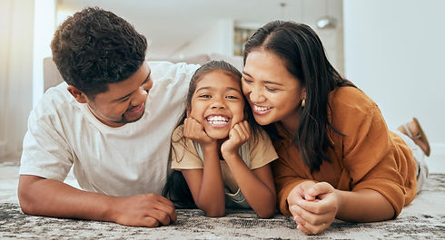 Happy family lying on the floor after having their HVAC unit replaced by Daflure Heating Cooling and Solar