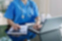 Dialysis nurse and operations manager adding up dialysis program costs on computer with help of calculator