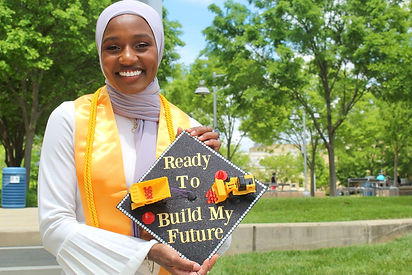 Najhmah, a new futures scholar, holding onto her decorated graduation cap that says "Ready to build my future"