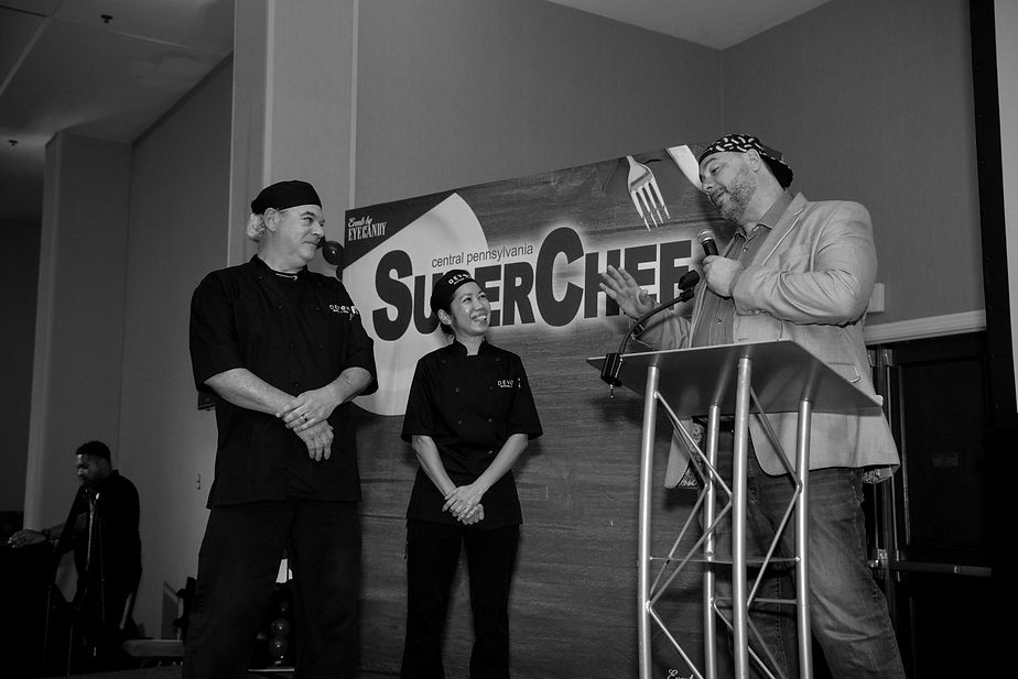 Michael Verber, host of Central PA SuperChef 2025, talking with chefs on stage about their cuisine