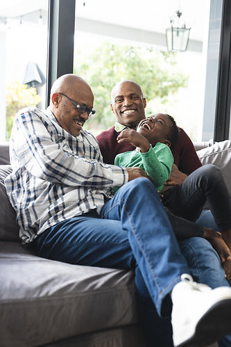Father, son, and granddaughter laughing on their couch after having Daflure provide their Camp Hill PA home with air conditioning repair