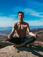 Man on top of a mountain meditating