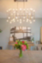 Energy-efficient lighting fixture over a dining room table with pink and green flowers on the top