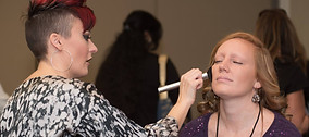 a vendor from The Conference for Women putting makeup on a guest