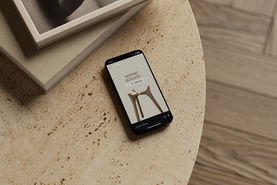 Story instagram sur un téléphone portable posé sur une table basse, représentant les produits et l'identité visuelle de Calm Design, artisan design de mobilier durable