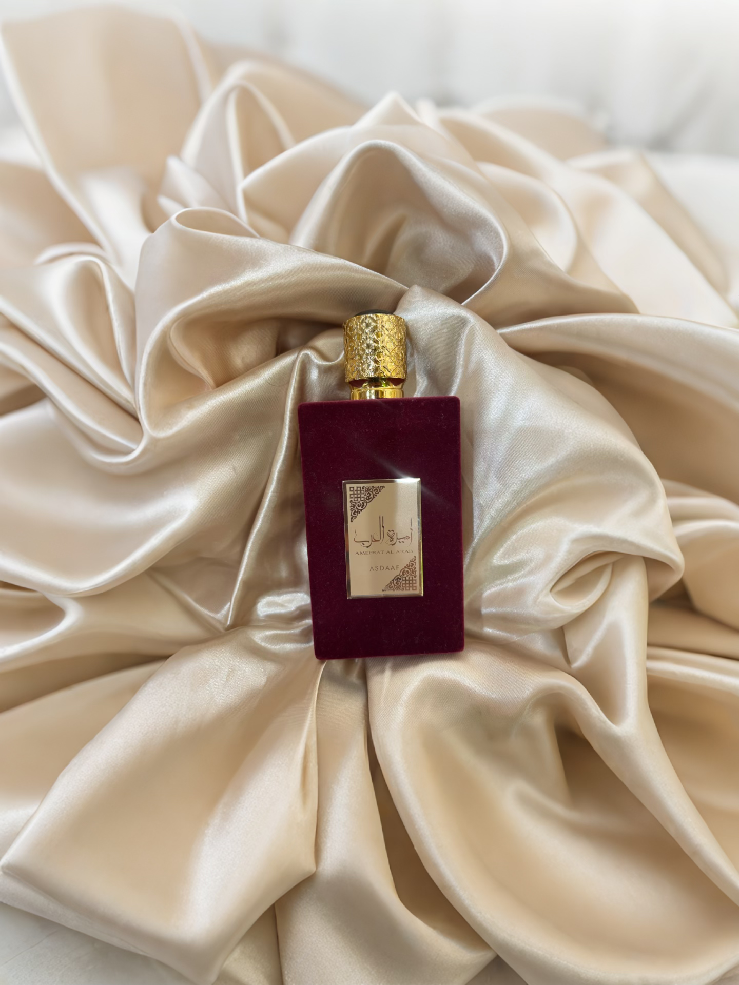 flacon en velours rouge avec plaques et ecritures dorees sur voilage dore