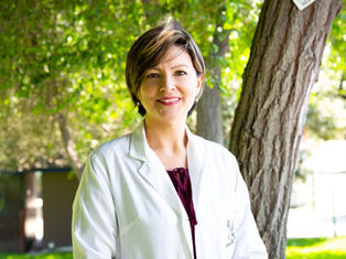 A physician standing in front of a tree