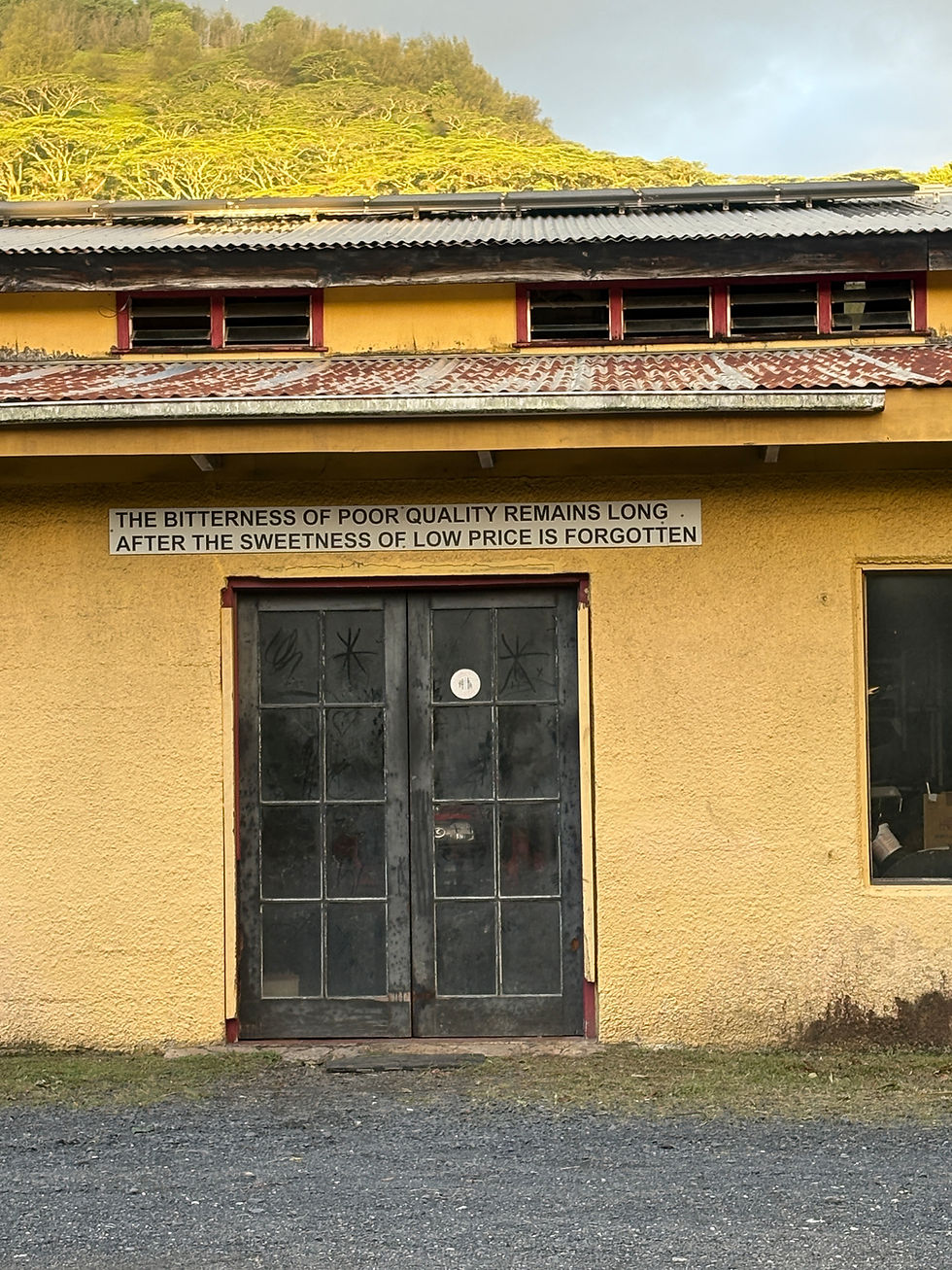 Island wisdom, delivered without fuss: a weathered sign offers a reminder that poor quality is remembered long after a bargain is forgotten.