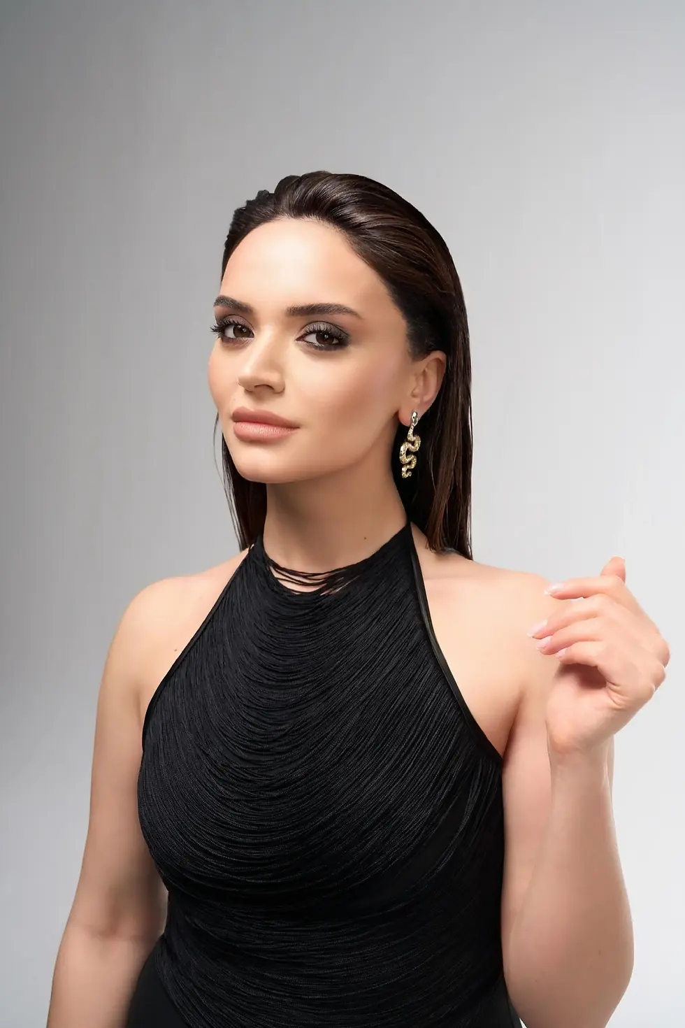 Ebru Yaman stüdyo fonu önünde duruş pozu veriyor.