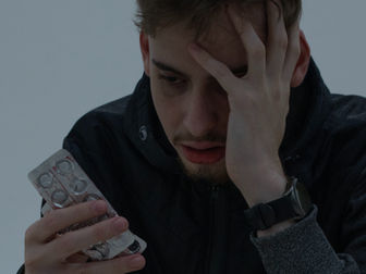 Jovem observando medicações para tratamento de ansiedade e depressão