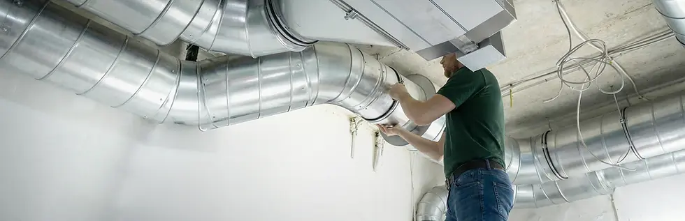 Green Duct Services technician inspecting and working on exposed HVAC ductwork in a commercial space, ensuring proper airflow and system performance.