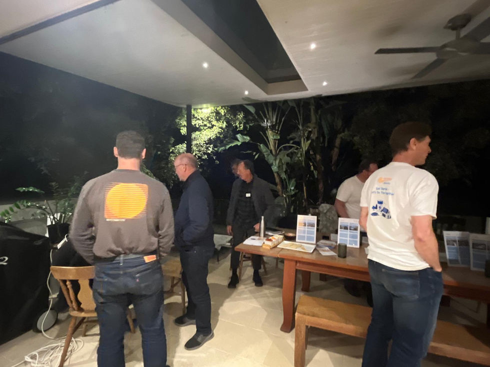 People standing in front of table reading information. 