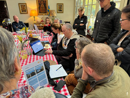 Man sitting at iPad explaining to group