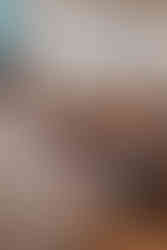 Perhe ja päivänsankari istuvat ja hymyilevät kastetilaisuudessa ristiäiskuvauksessa Helsingissä. Juhlakuvas Vantaa, Helsinki, Espoo.