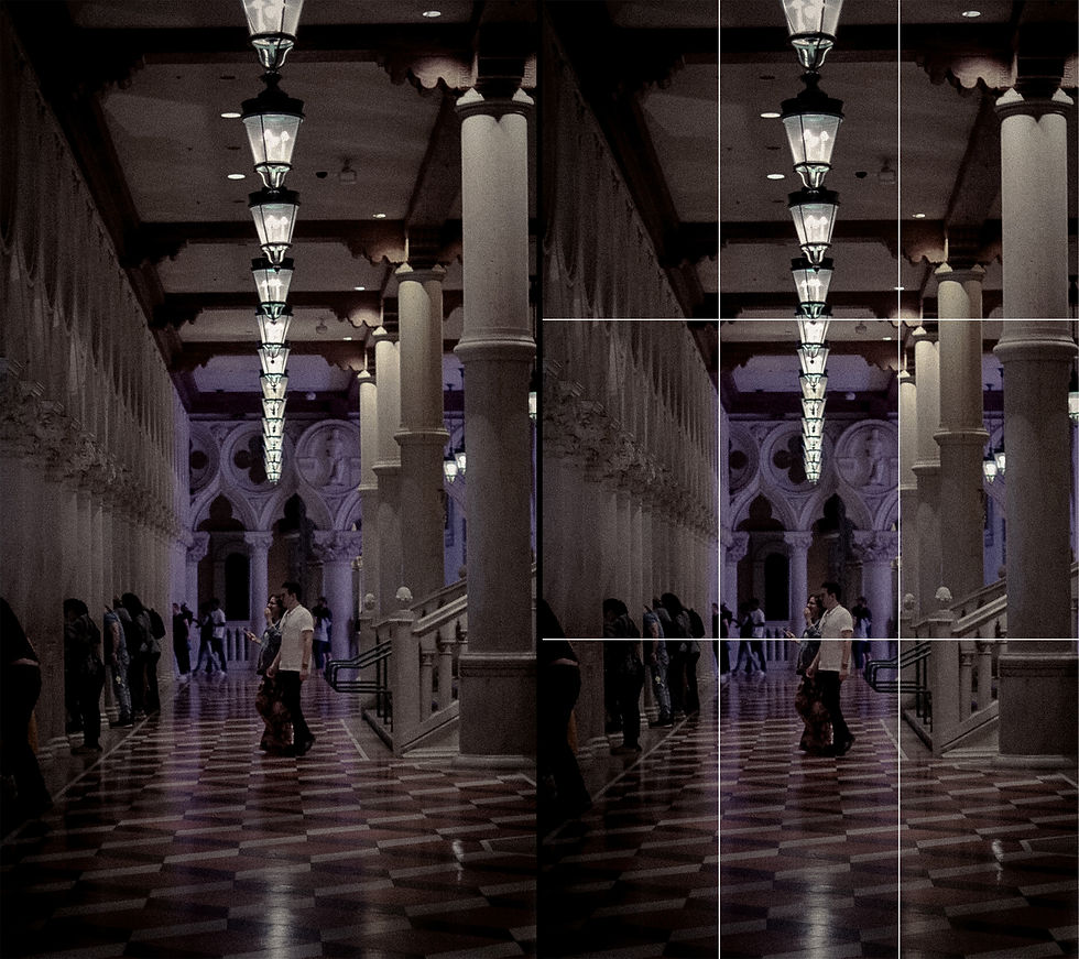 A hallway with columns and hanging lights, people walking in a dark room. A checkered floor and dim lighting create a calm atmosphere.