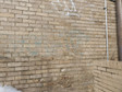 Tan brick wall with graffiti