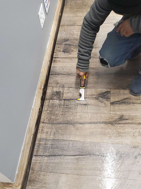 Person using tool on wood floor