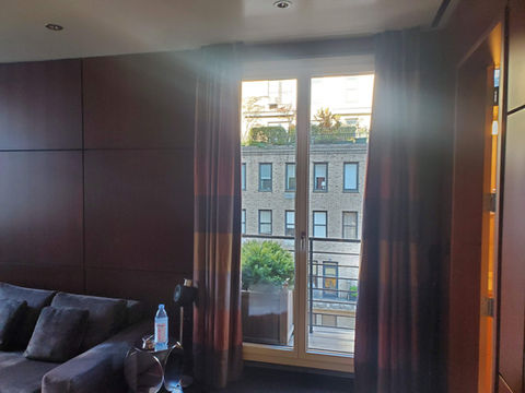 Sunlit room with city view through French doors
