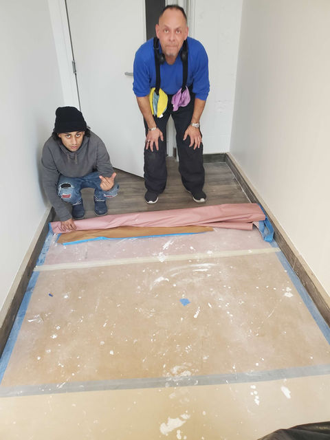 Two workers installing new flooring, Crazy Clean