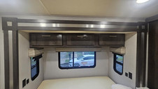 RV bedroom overhead cabinets and window