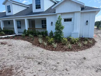 Newly landscaped white house with bare soil