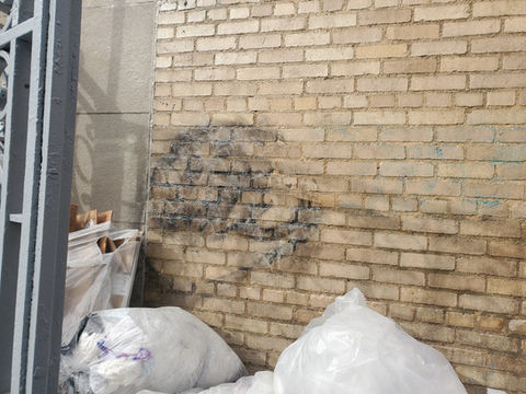 Soiled brick wall with dark stain