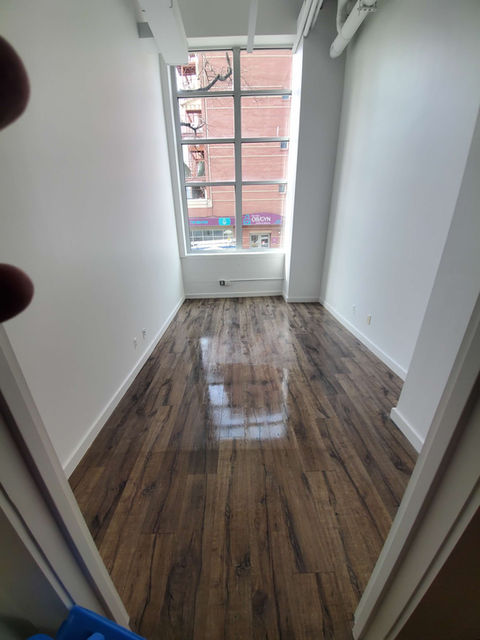 Clean room with shiny hardwood floors and large window