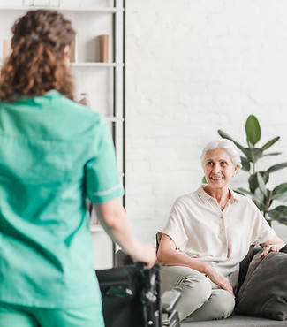 nurse-with-wheelchair-standing-ion-front-happy-female-patient.jpg