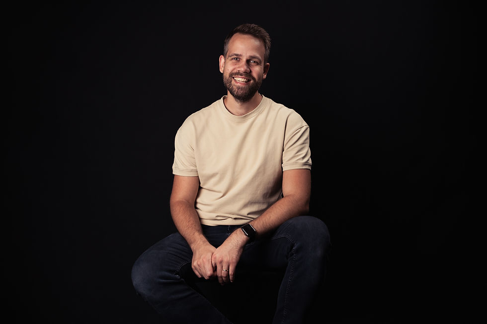 Oliver Kobak smiling against a dark background