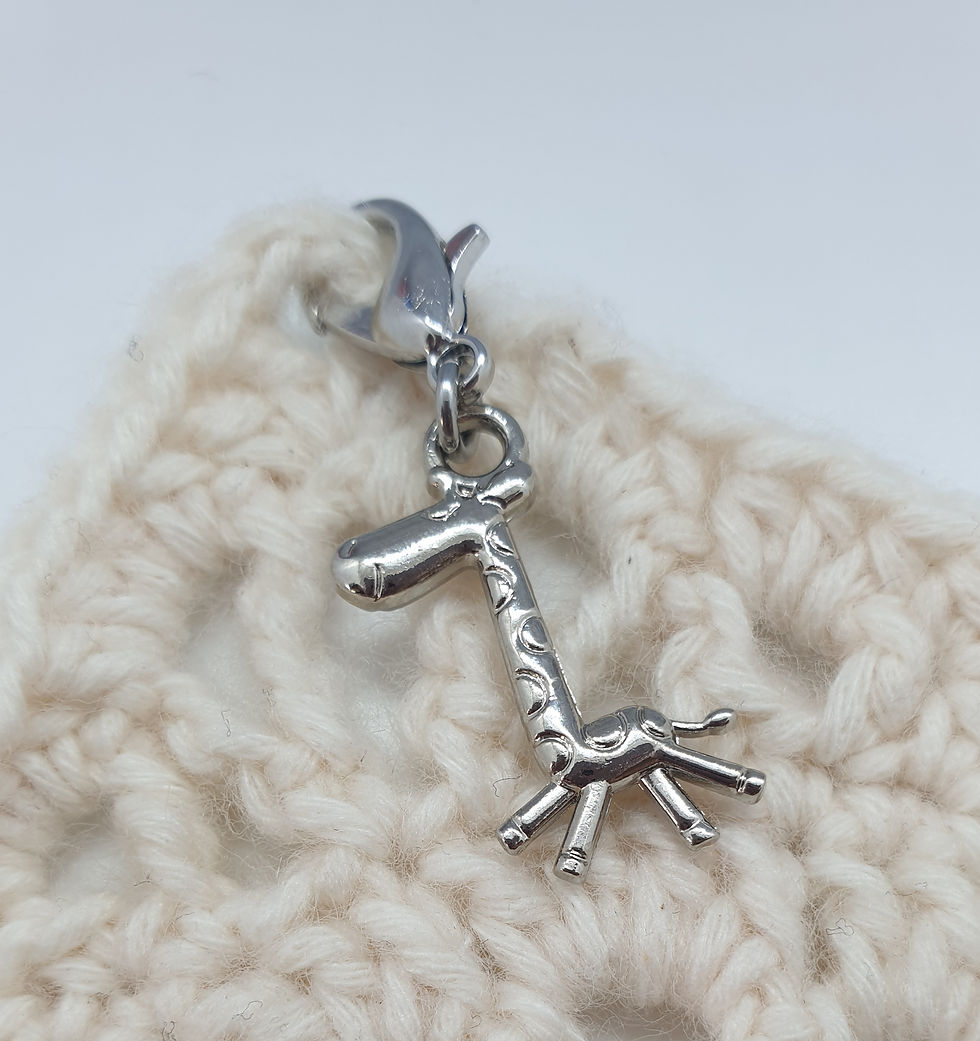 Thumbnail: cute giraffe shaped silver coloured metal charm with lobster clasp on crochet square background