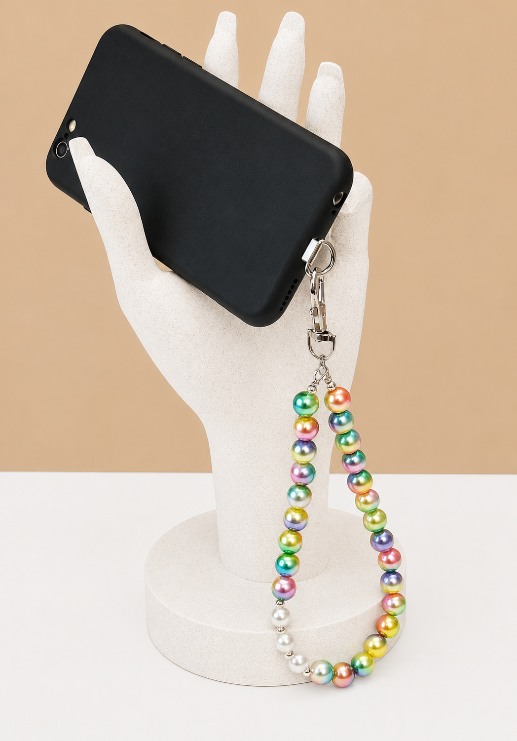 rainbow bead wrist strap with mobile phone tether tab in phone displayed in hand
