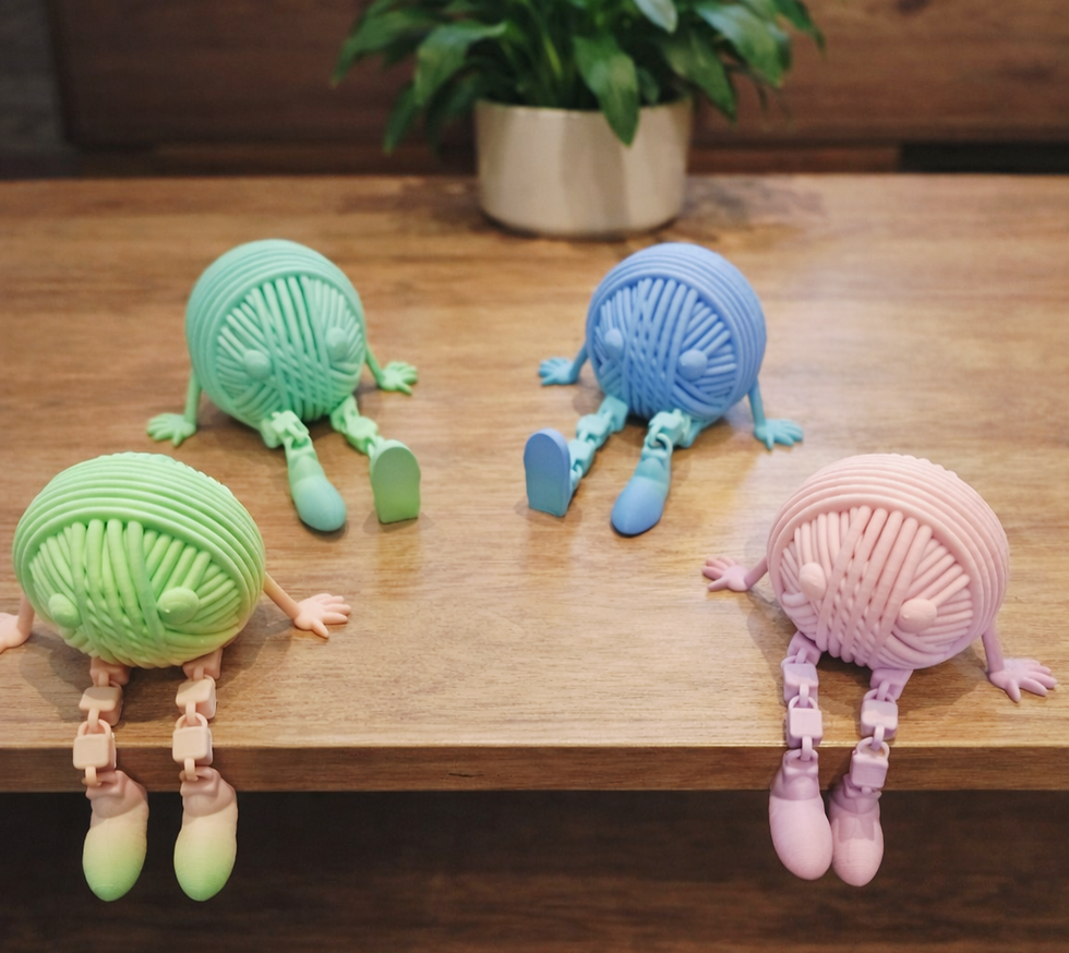 Thumbnail: 4 coloured yarn buddies on a wood table