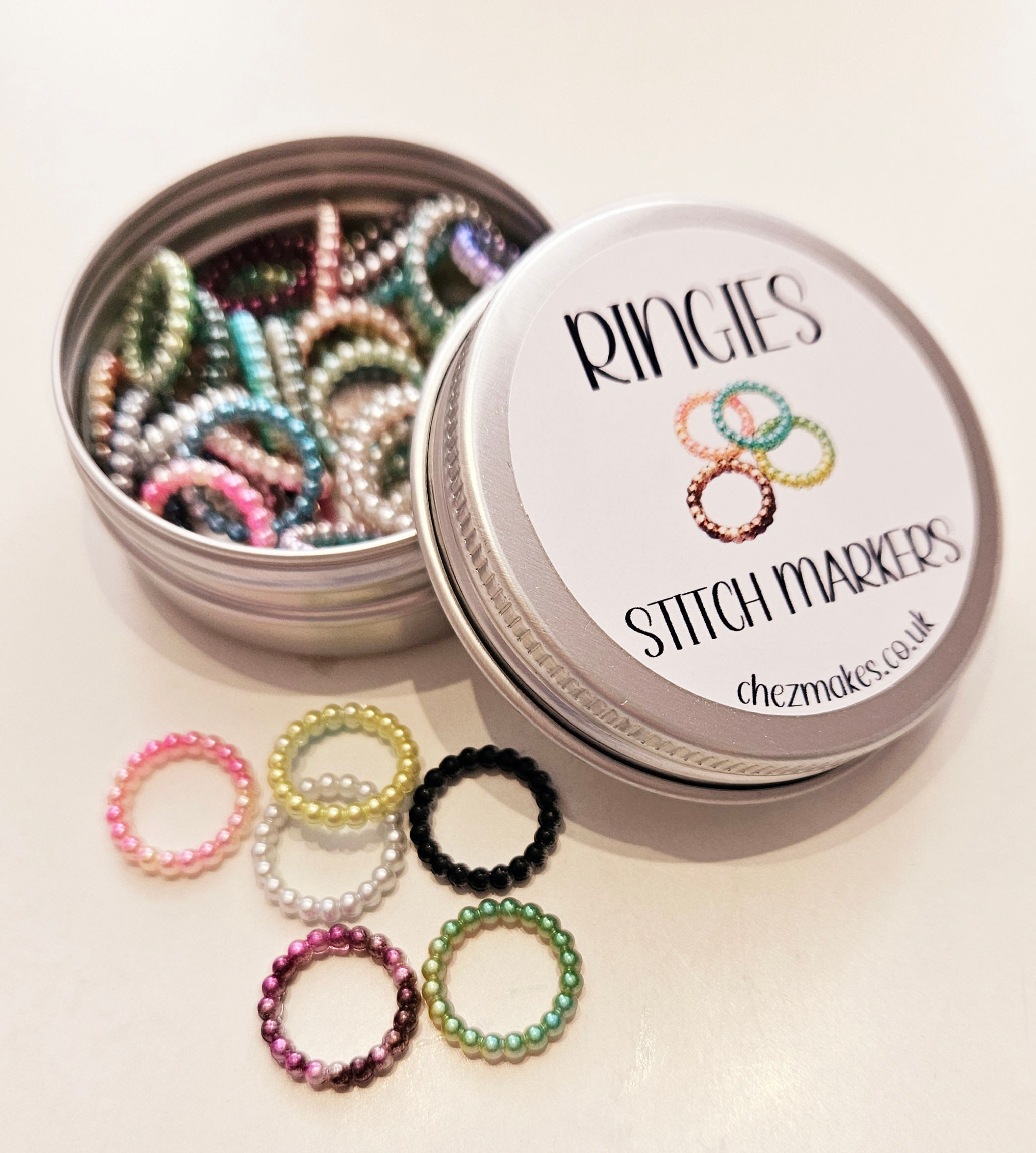 ringies stitch markers tin with multi coloured plastic rings inside and some out. Each ring is textured with little bobbles