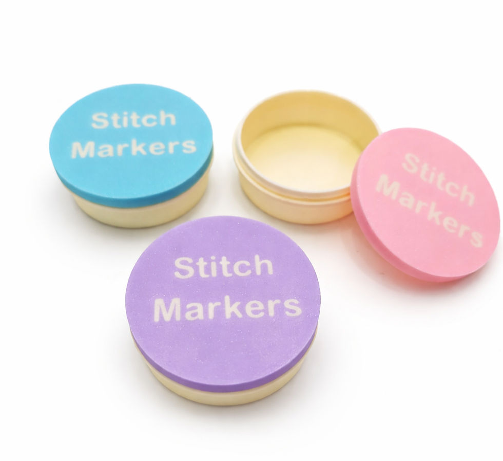 Thumbnail: three round stitch markers boxes the blue and purple have lids on and the pink has the lid off
