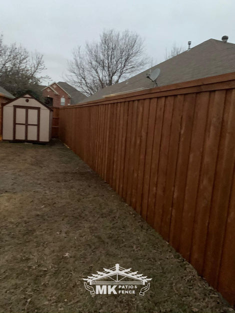 Newly installed backyard cedar privacy fence with rich stain finish by MK Patio Fence.