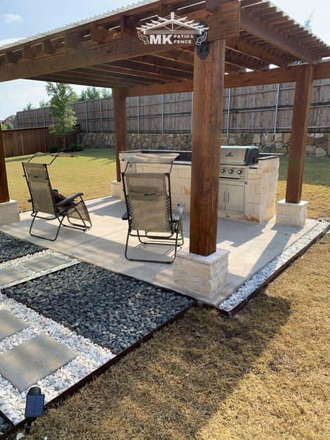 Wooden pergola with outdoor dining area and modern walkway featuring stone pavers and decorative gravel.