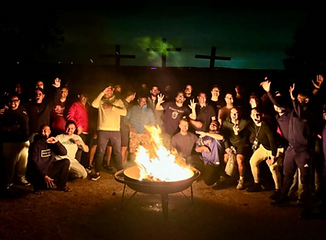 Grupo de homens reunidos ao redor de uma fogueira durante o encontro Fire Fighters da Father’s House Church.