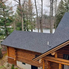 New dark grey shingle roof on a Hudsonville log home