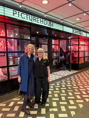 Two attendees outside a cinema promoting the Mother Vera screening.