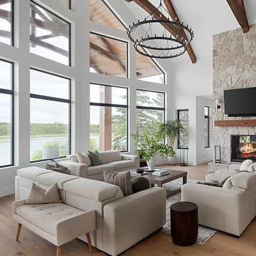living room, large, fireplace, stone fireplace, view, river view, bench, sofa, light, airy, light floors, large windows, chandelier, interior design, Saskatoon