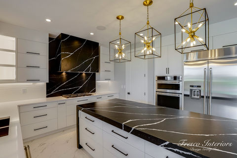black and white quartz, white countertop, black countertop, white cabinets, black hardware, gold lighting, modern style, marble flooring, double wall oven, horizontal pulls, bold kitchen