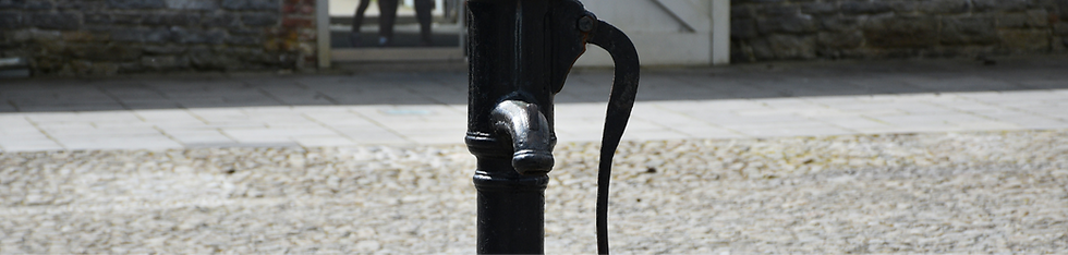 a black fire hydrant sitting on top of a cobblestone street_edited_edited.png