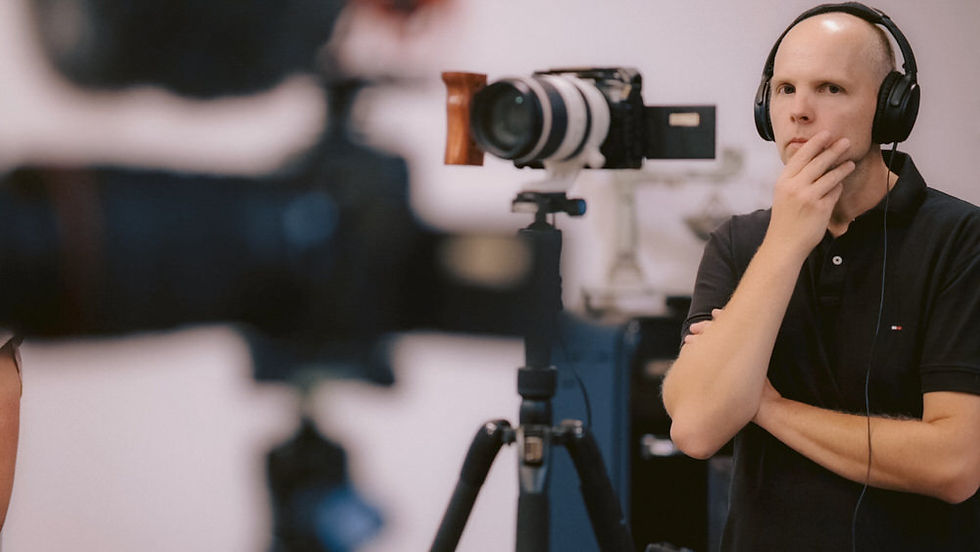 Mann mit Kopfhörern hinter Filmkamera
