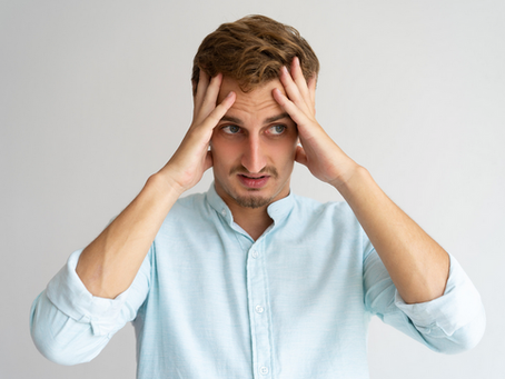 A frustrated person with hands to their head