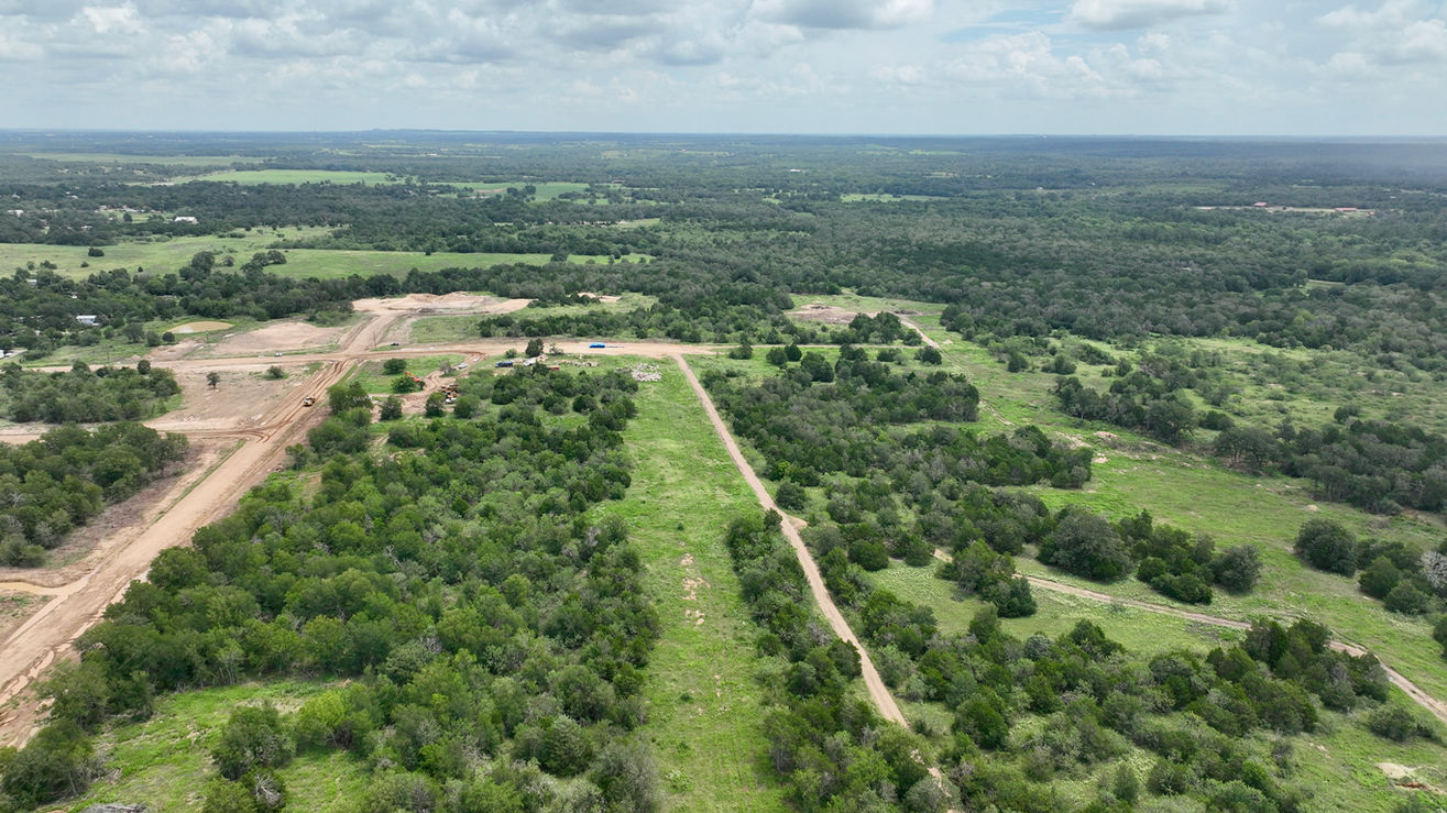 Open field and trees with construction areas visible at Camp Swift, TX