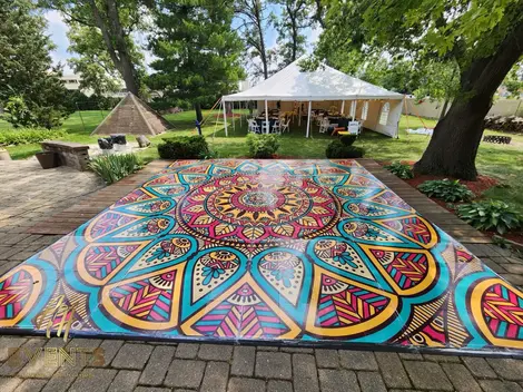 a colorful dance floor in front of a white tent