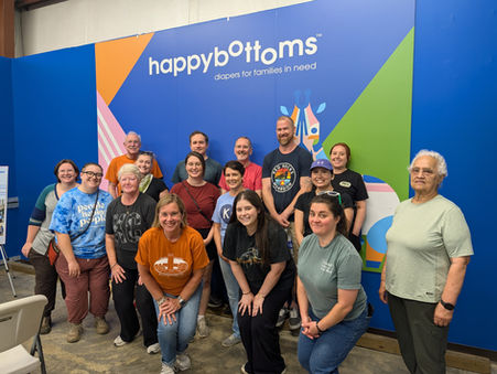 Waldo volunteers standing in front of a HappyBottoms logo