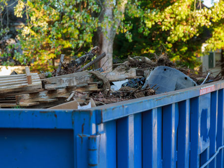 blue dumpster filled with debris