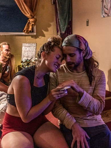 Two people sitting closely and talking at a Seattle Ecstatica event
